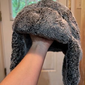 Fuzzy warm winter hat with straps on ear flaps.